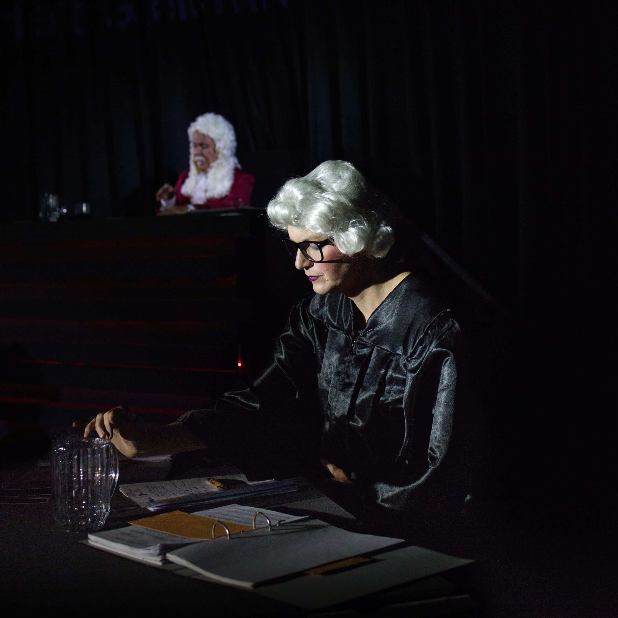 Staatsanwältin Ms. Meyers und der Richter schauen in ihre Unterlagen.